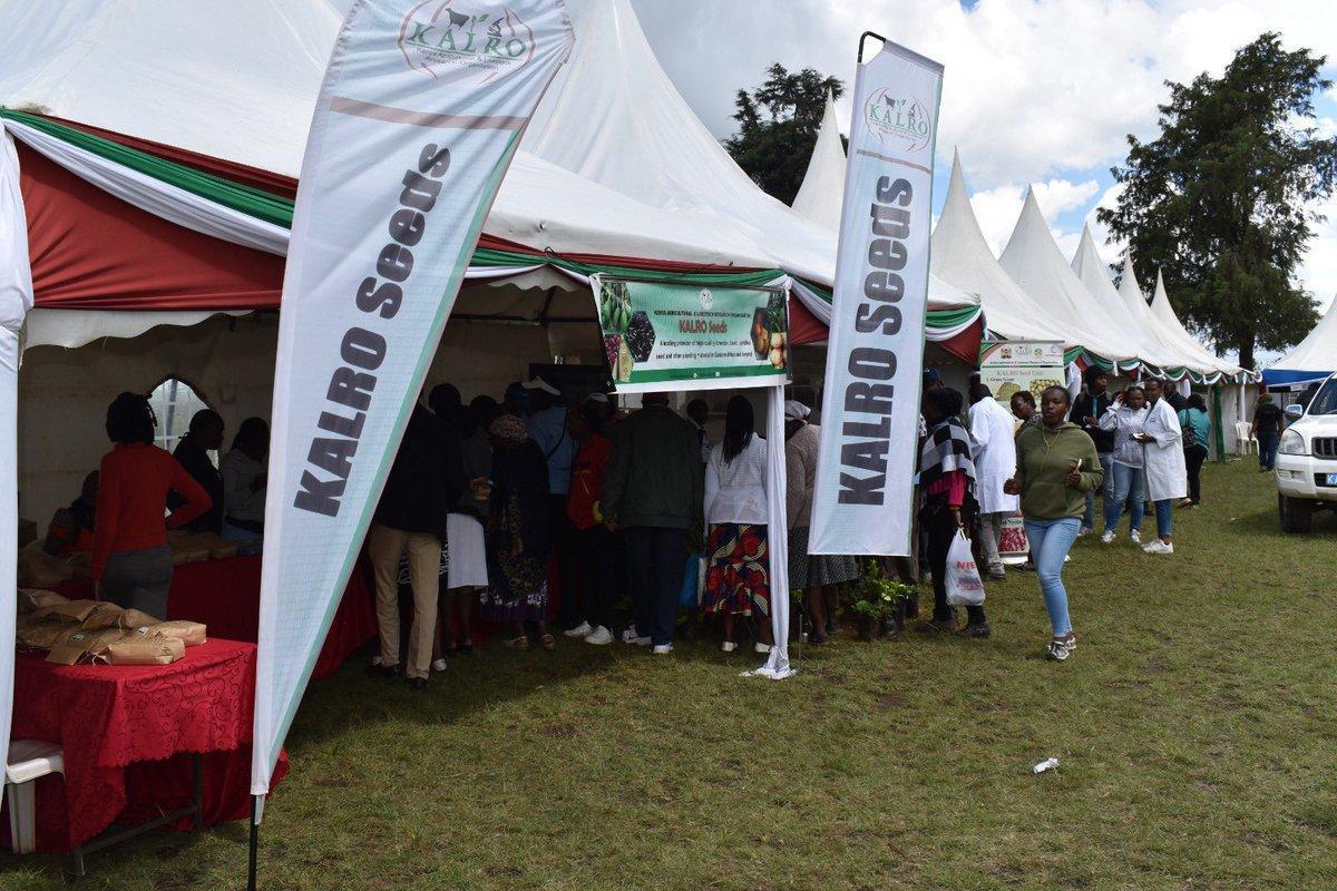 Exhibitors and visitors at an agricultural exhibition tent